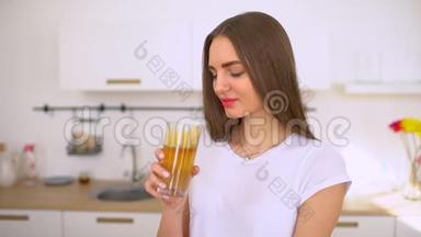 苹果汁-女人在厨房里榨汁和喝新鲜的苹果。 果汁机和健康饮食快乐